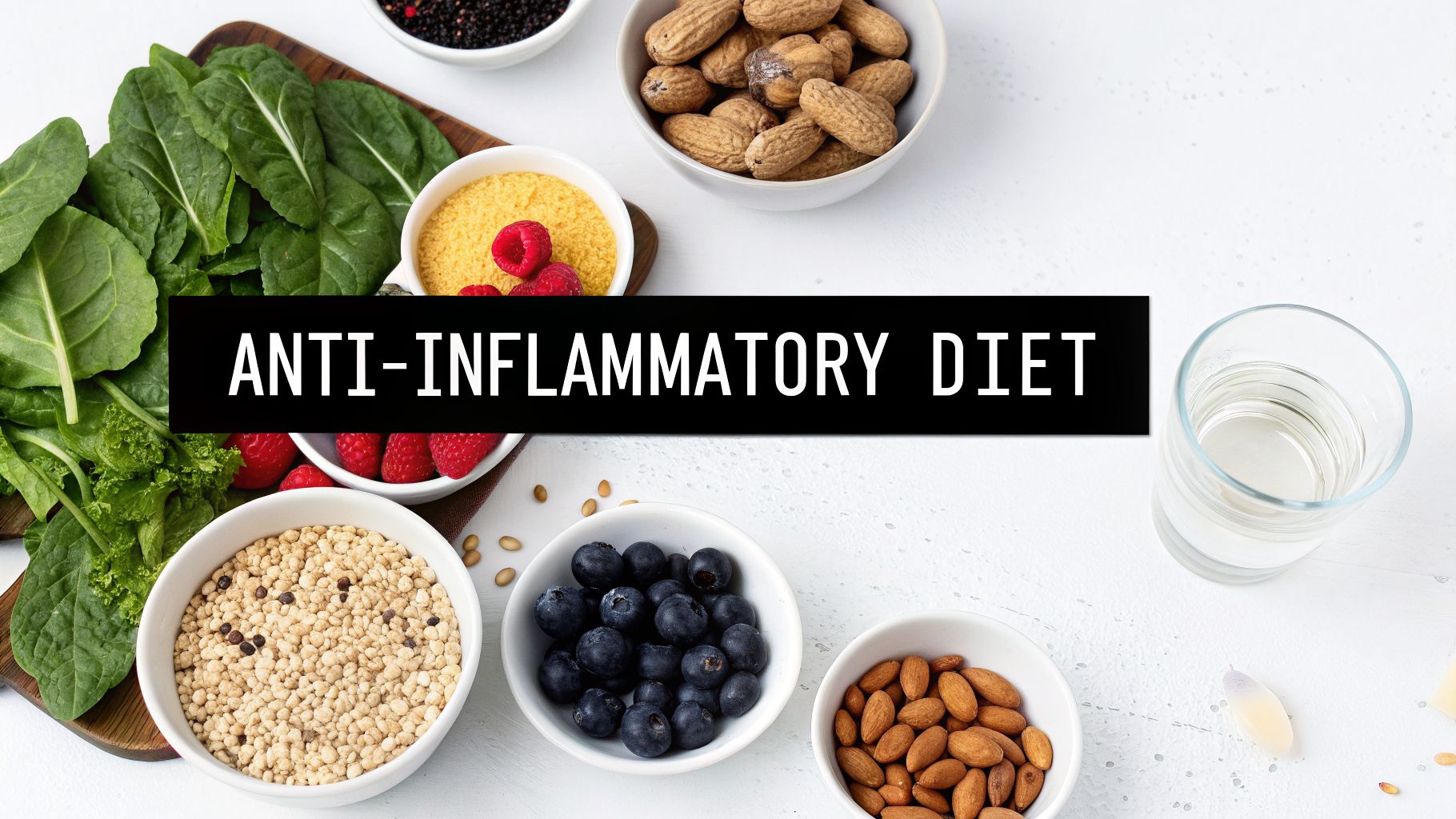 Overhead view of various healthy foods like spinach, berries, nuts, and grains for an anti-inflammatory diet.