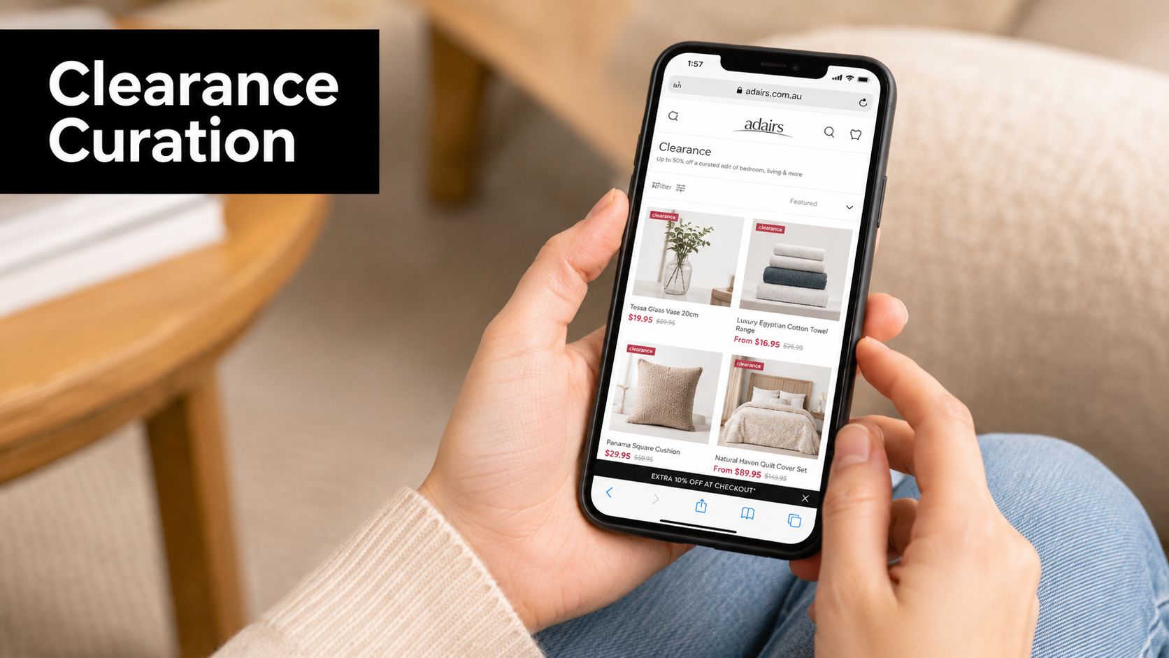 A person holding a smartphone showing an online shopping website displaying various discounted home decor items.