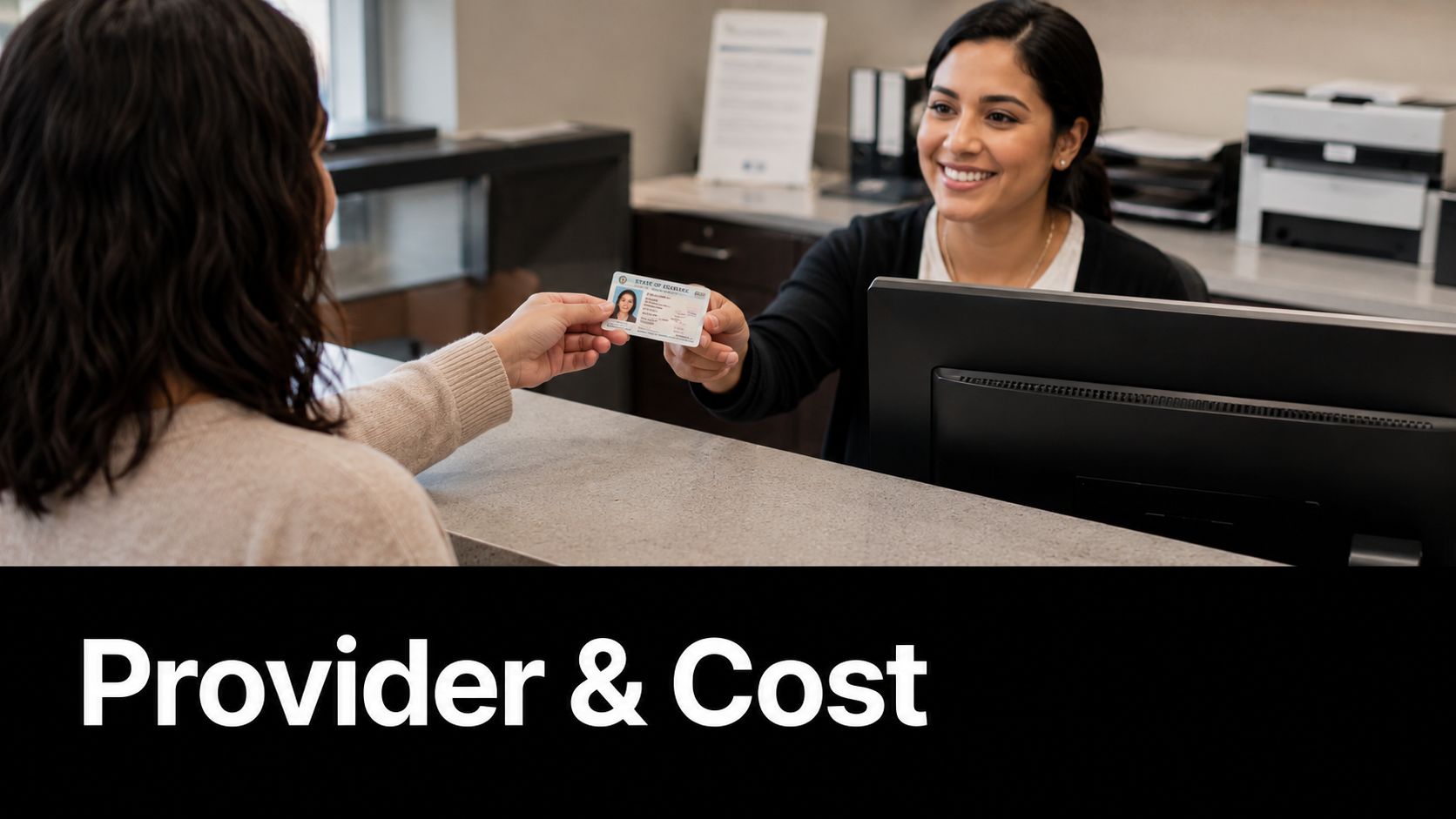 A smiling receptionist at a front desk receives an identification card from a customer for processing.