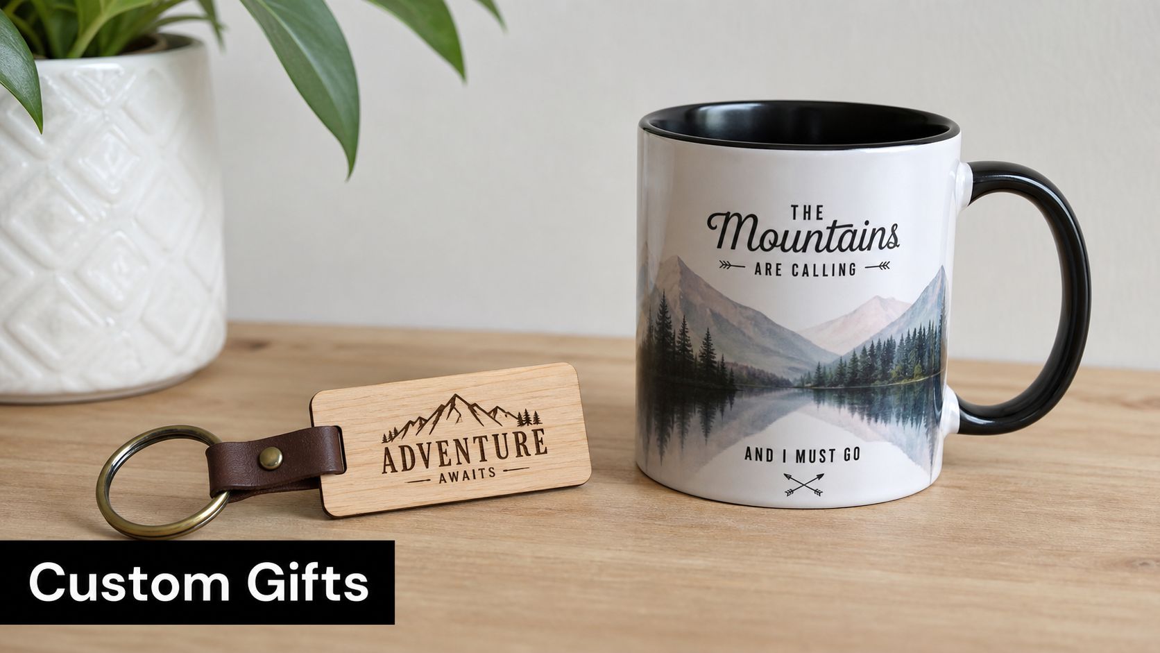 A custom wooden keychain and a mountain-themed ceramic mug displayed on a wooden surface with a plant.