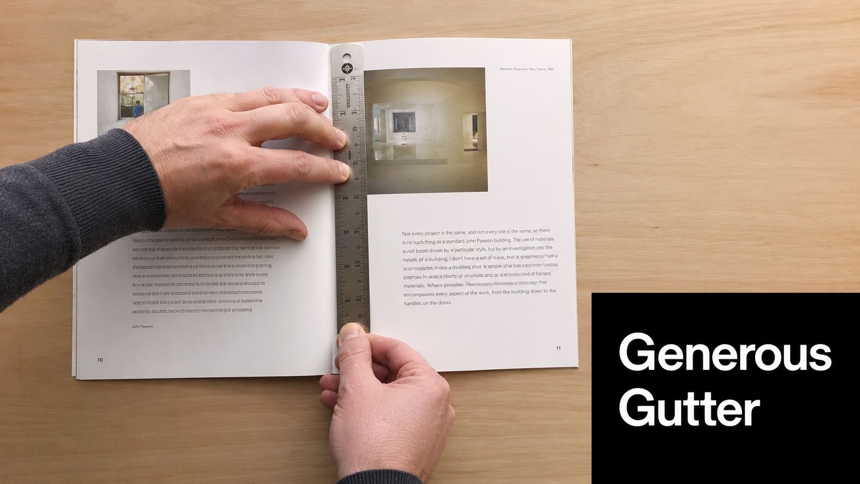 A person holds a metal ruler across the middle of an open book to measure the center gutter.