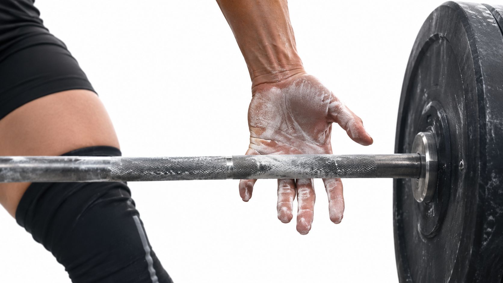 A weightlifter's chalk-covered hand resting on a barbell before a heavy deadlift attempt.