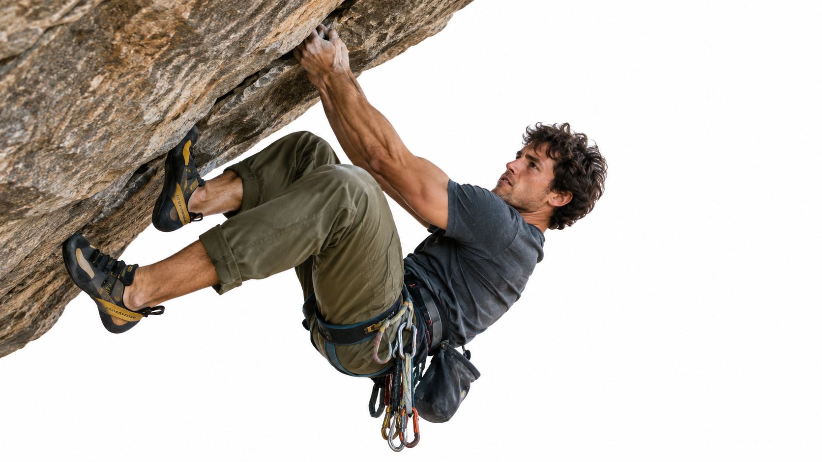 A rock climber performing a challenging overhanging route using technical footwork and climbing gear on rock.