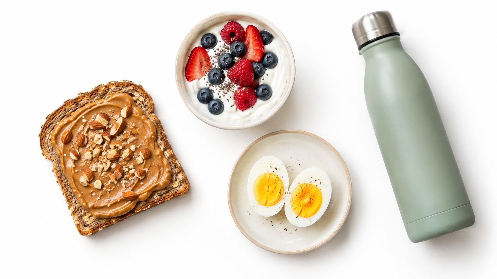 A healthy breakfast flat lay featuring whole grain toast with almond butter, yogurt with berries, and eggs.