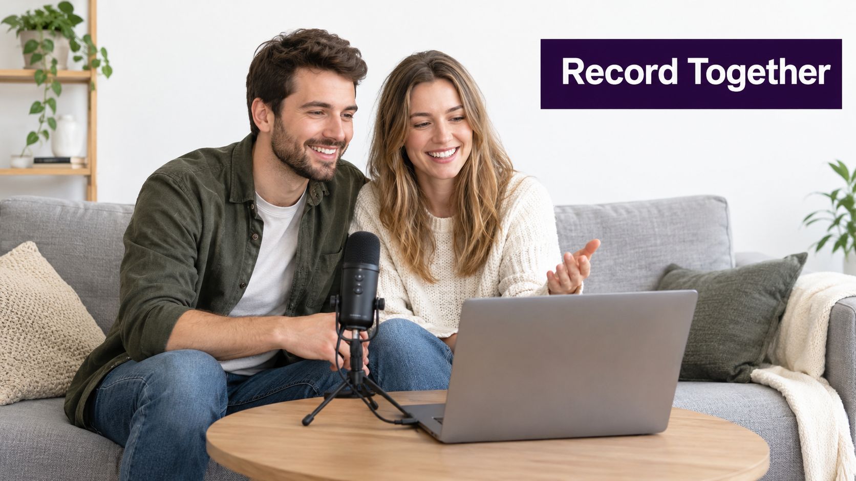 A happy couple sitting on a couch together while recording a podcast with a microphone and laptop.