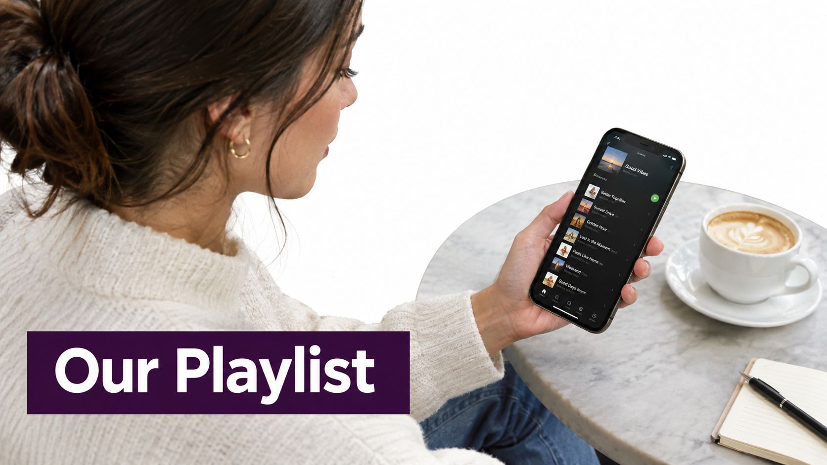 A woman looks at a smartphone screen displaying a music playlist while sitting at a cafe table.
