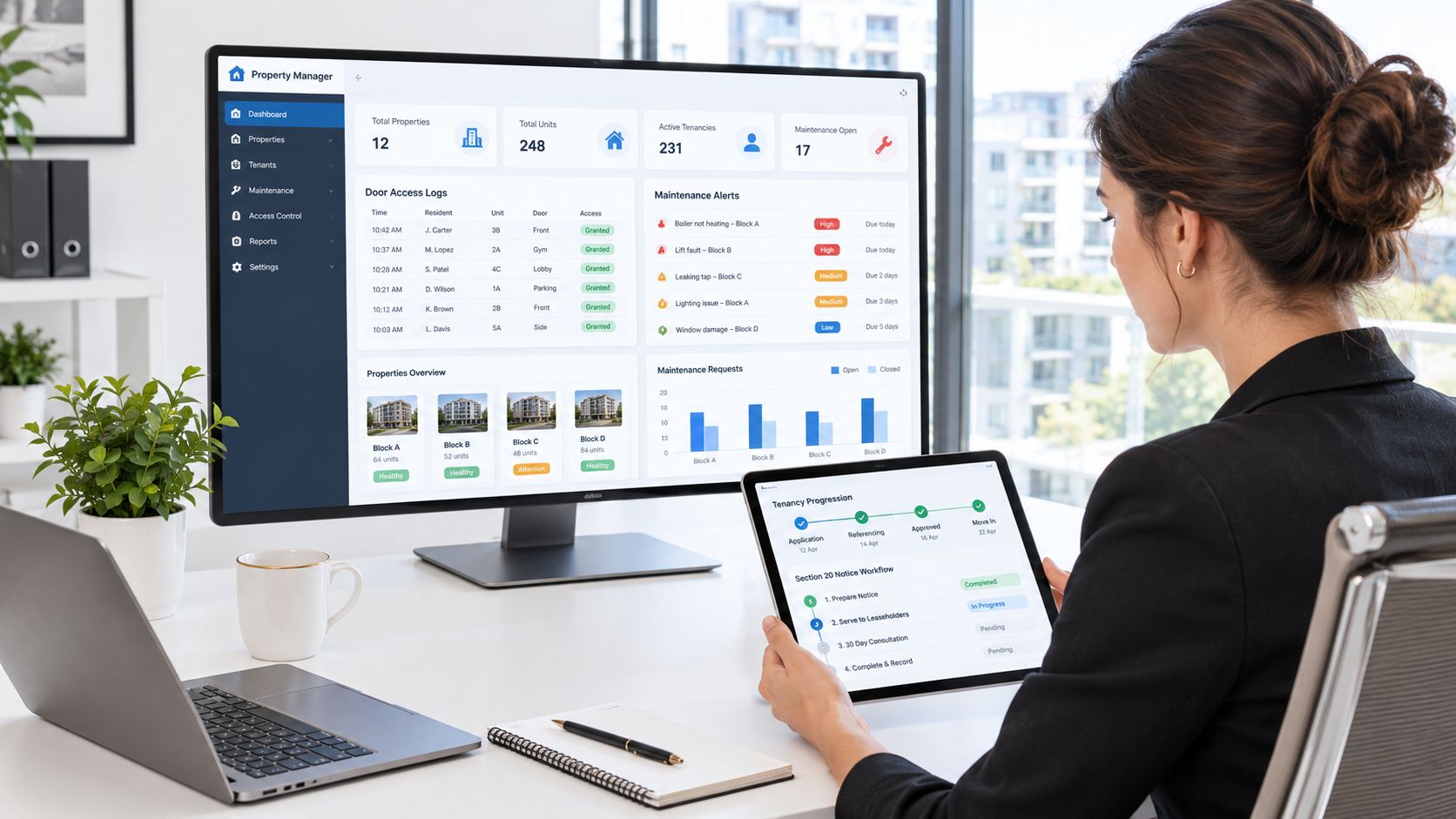 A professional working on a property management dashboard on a desktop computer and a tablet device.