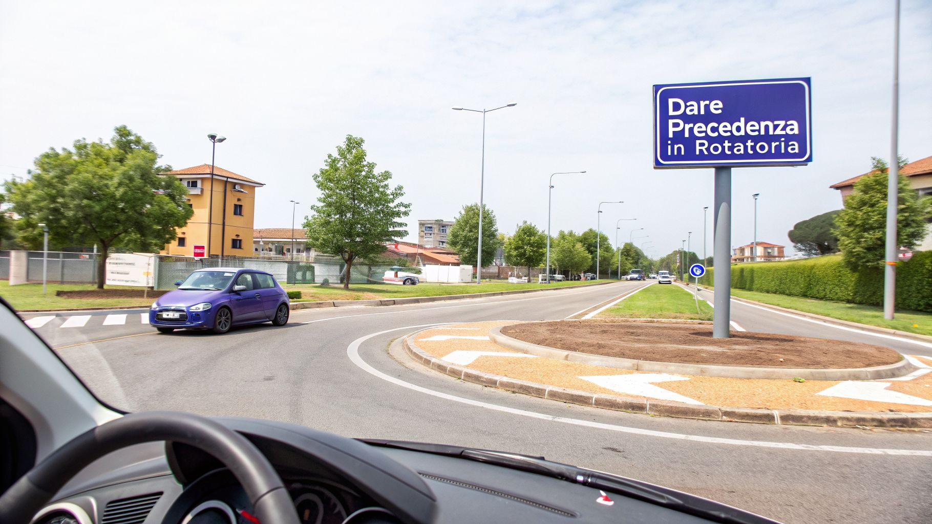 Un'auto blu si avvicina a una rotonda in Italia, con un cartello che indica di dare precedenza.