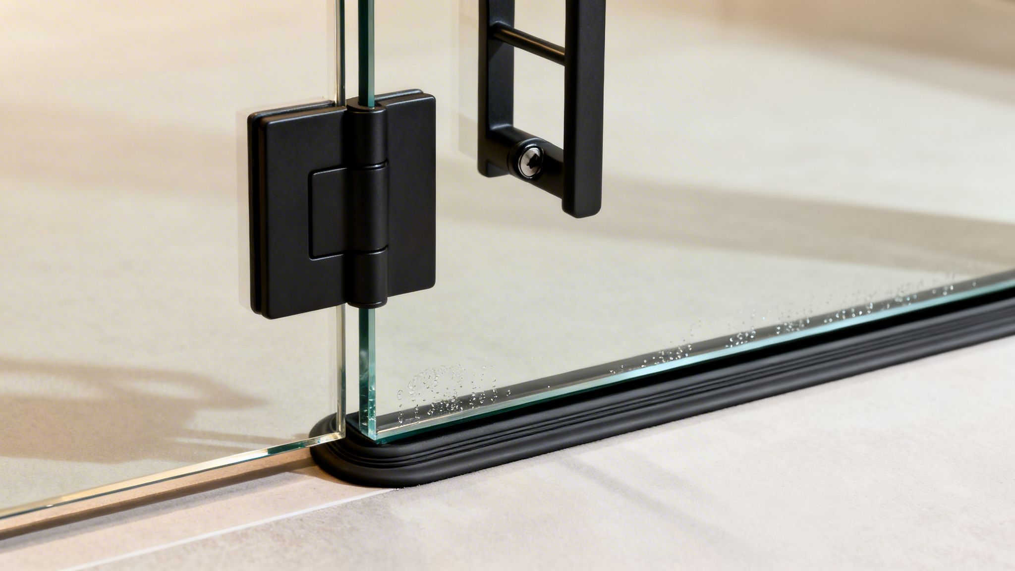 Modern glass door with sleek black hinges and handle, featuring a bottom seal and water droplets.