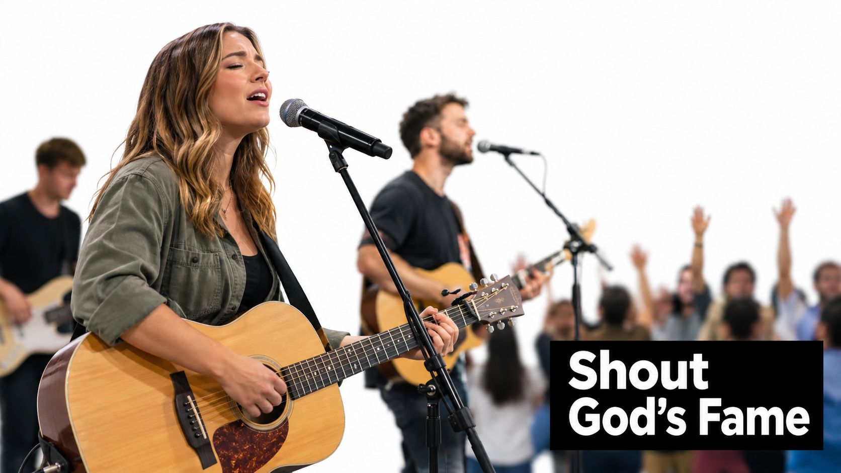 A female musician singing and playing acoustic guitar on stage, with a band and audience behind her.