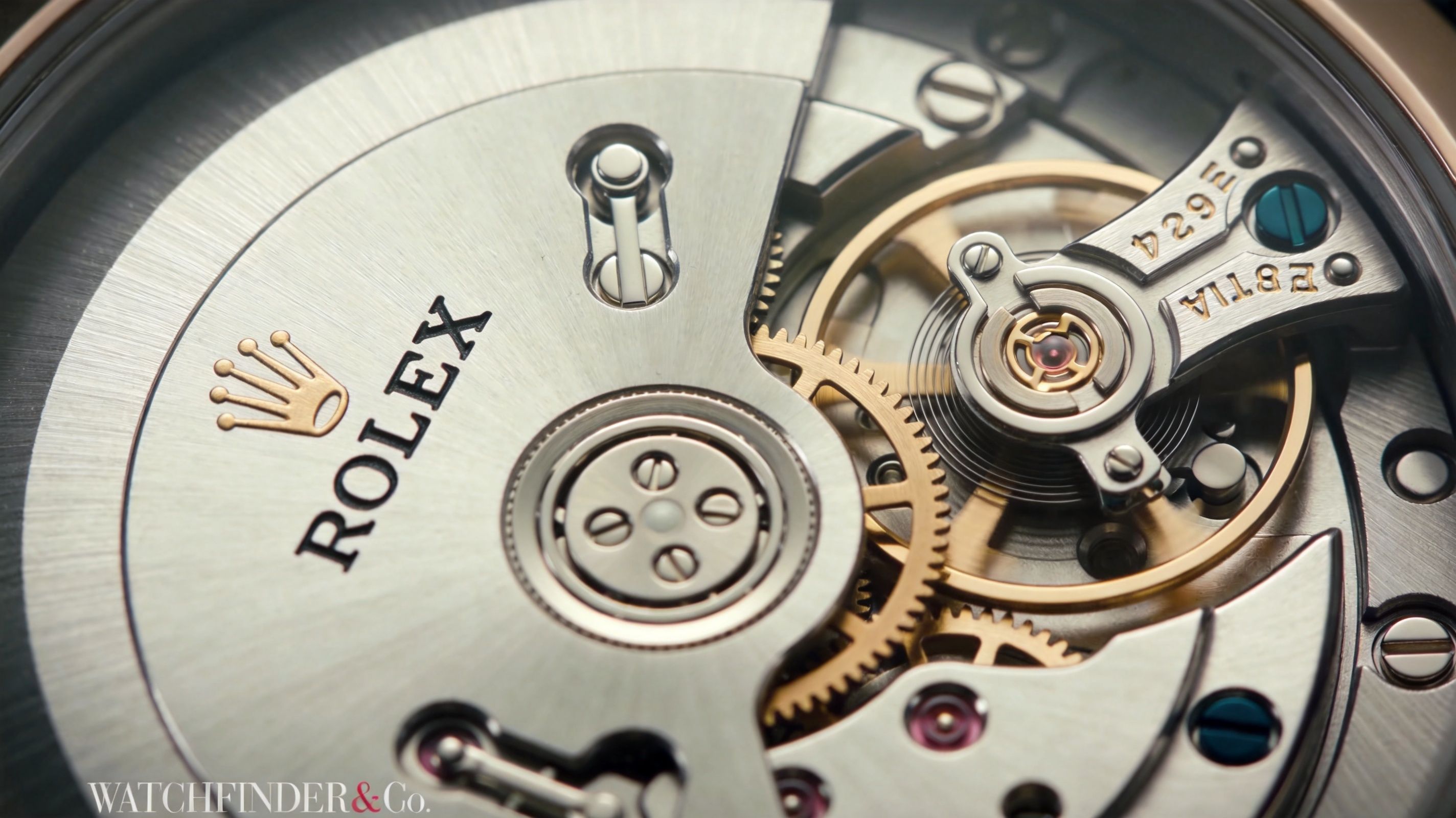A close-up view showing the intricate mechanical movement and balance wheel of a luxury Rolex wristwatch.