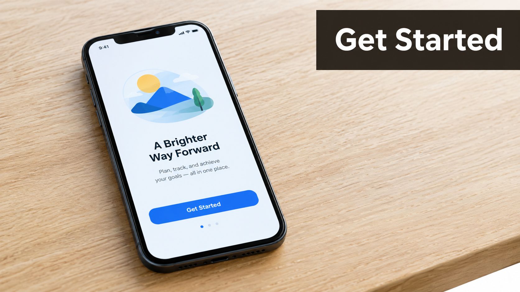 A modern smartphone displaying a clean onboarding app screen with a mountain illustration on a wooden table.
