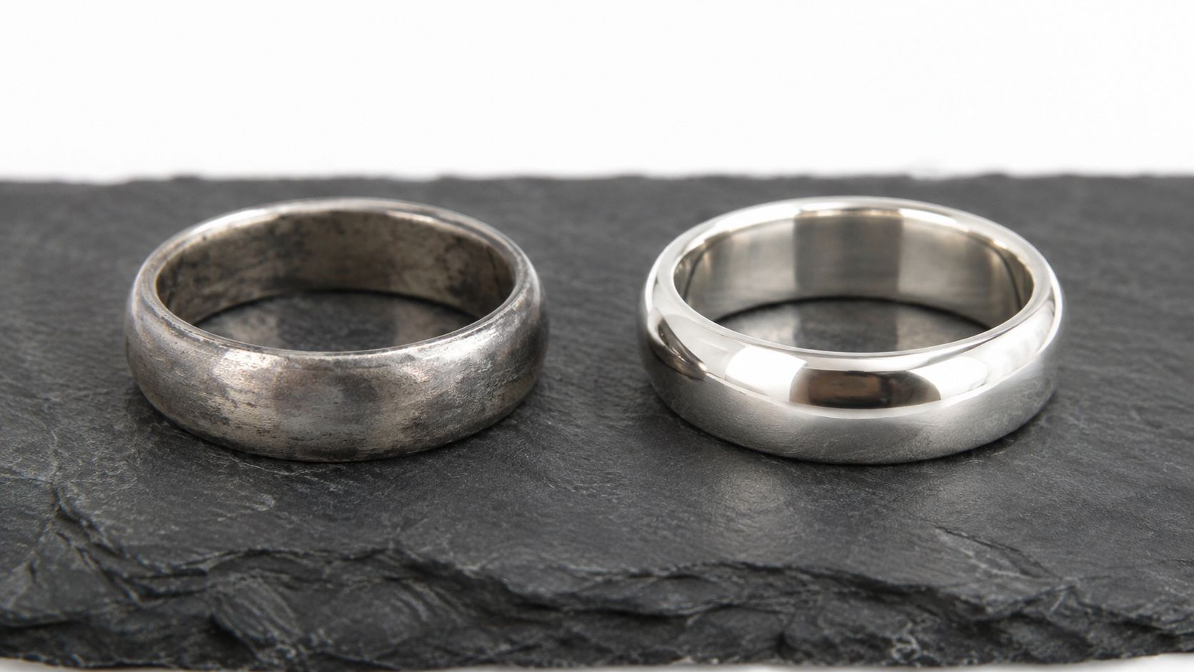 A comparison of a tarnished sterling silver ring next to a polished and shiny silver ring.