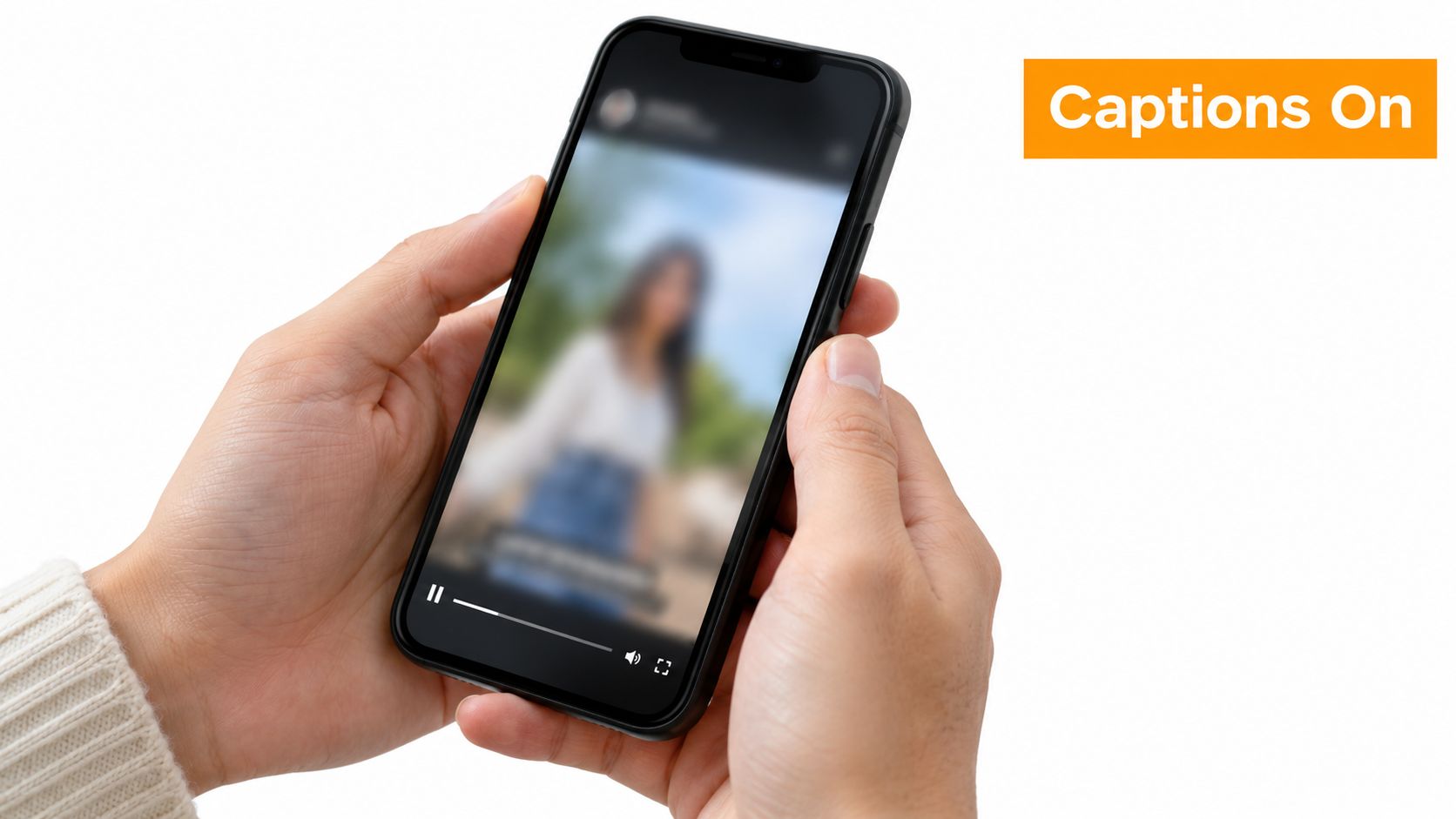 A person holding a black smartphone displaying a video with captions on against a plain white background.