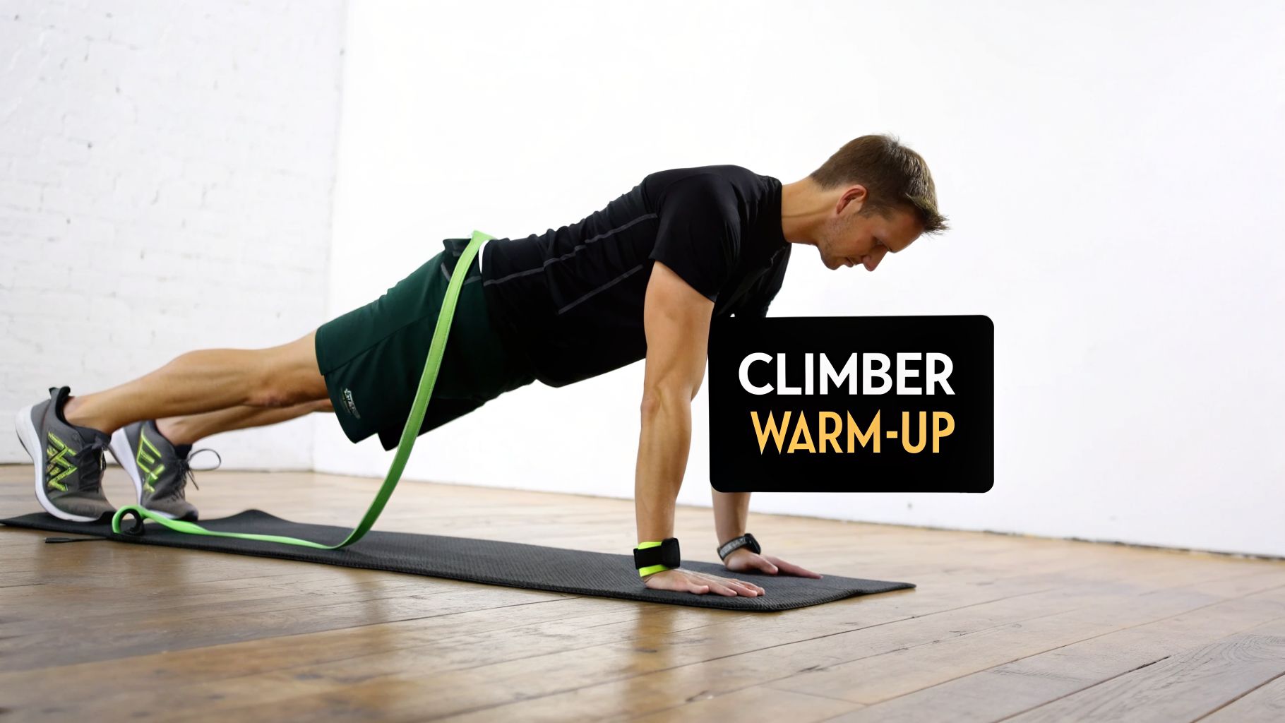 A man in a plank position with a resistance band, performing a climber warm-up on a mat.