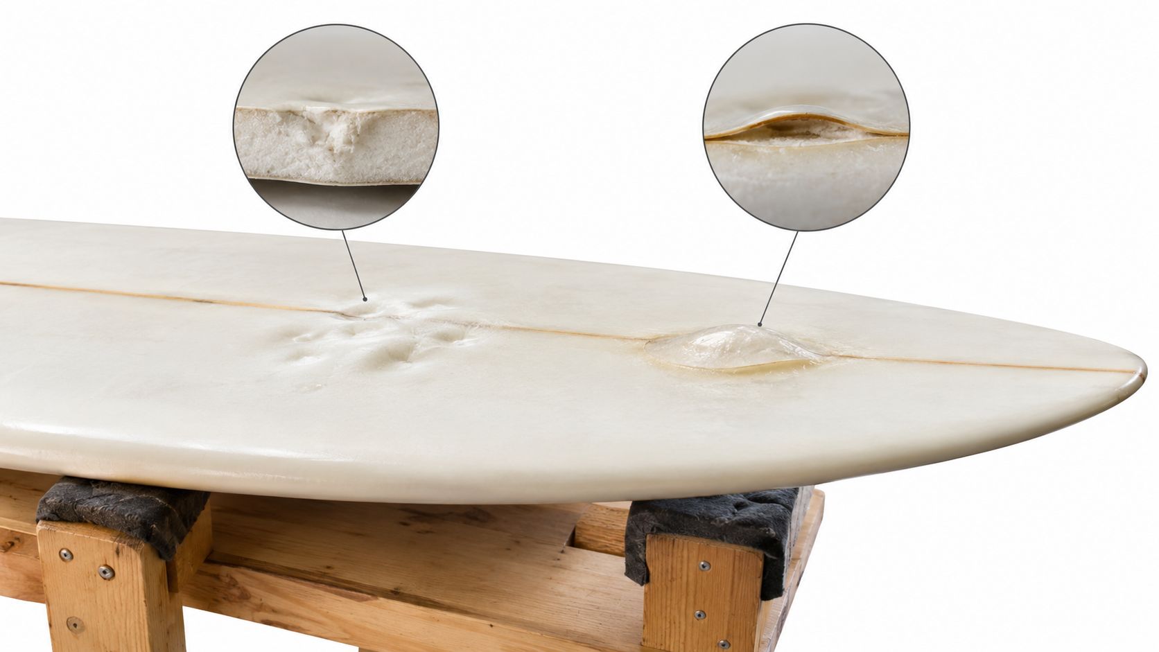 A close-up view of a damaged surfboard showing foam delamination and surface cracks on a wooden stand.
