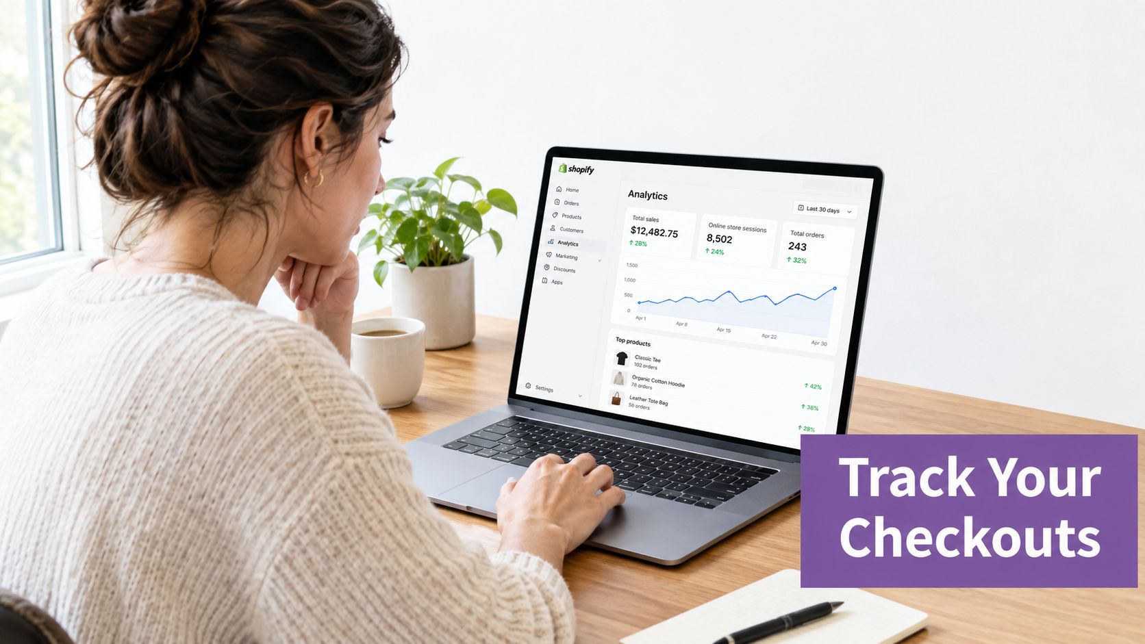 A woman reviewing her Shopify e-commerce business analytics on a laptop while sitting at her desk.