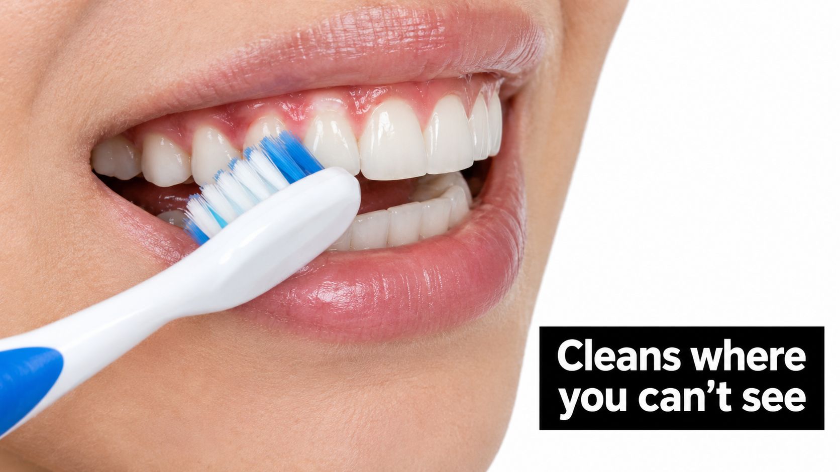 A close-up view of a person using a white toothbrush to perform a deep clean on their gums.