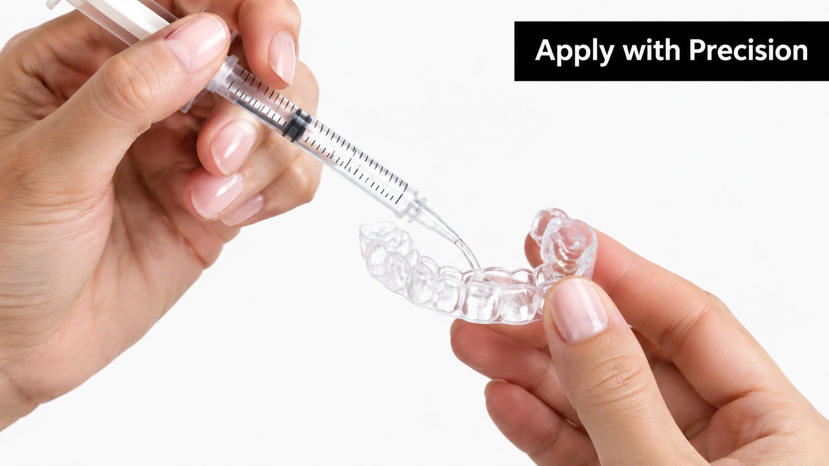 A pair of hands applying teeth whitening gel from a syringe into a clear aligner tray.