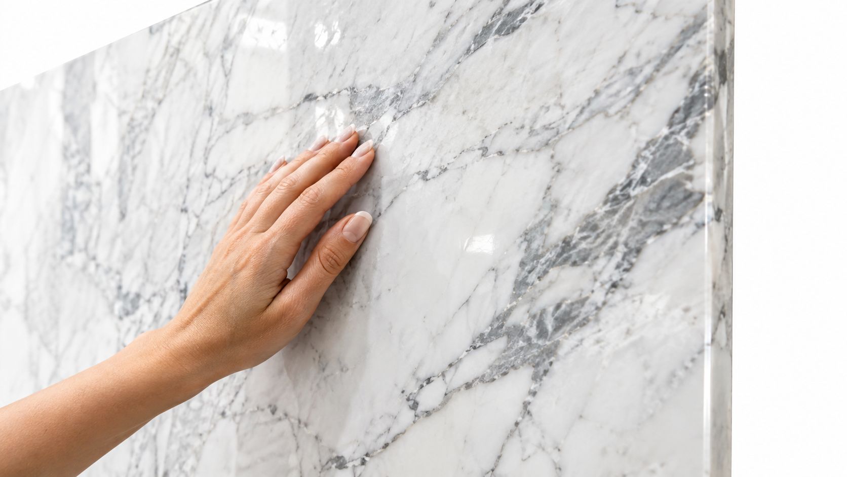 A close-up view of a woman's hand gently touching a polished piece of luxurious white marble slab.