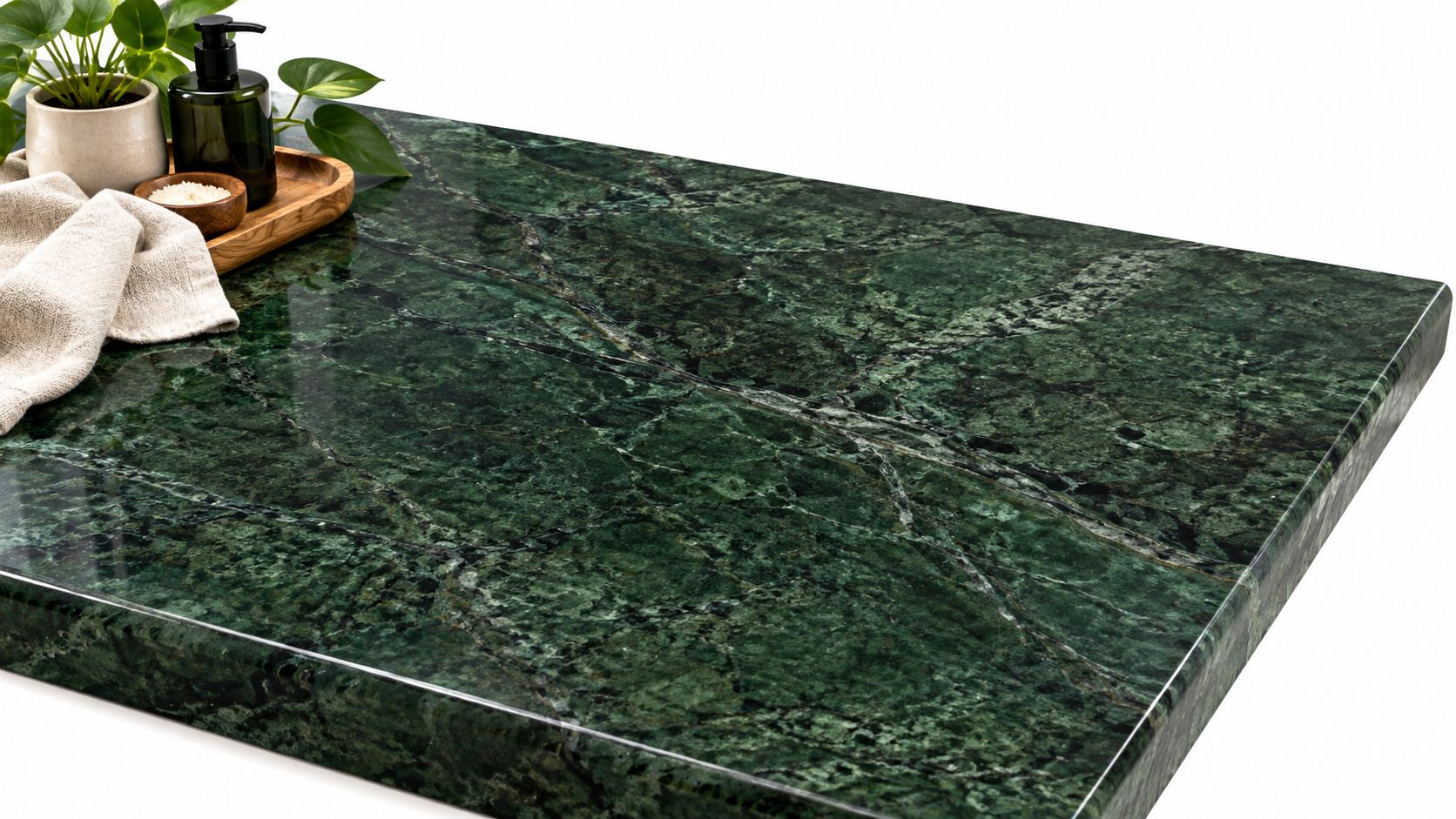 A luxurious green marble countertop surface with a plant, soap dispenser, and soft cloth on top.