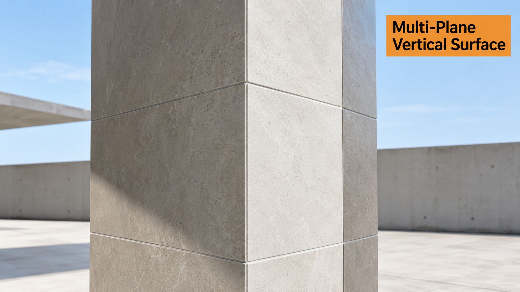 A close-up view of a modern structural pillar covered in smooth light gray stone tile cladding.