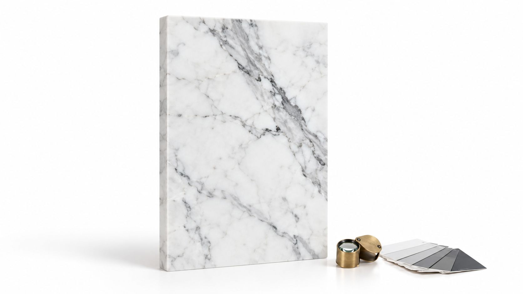 A rectangular slab of white Italian marble with gray veining beside a magnifying glass and color swatches.