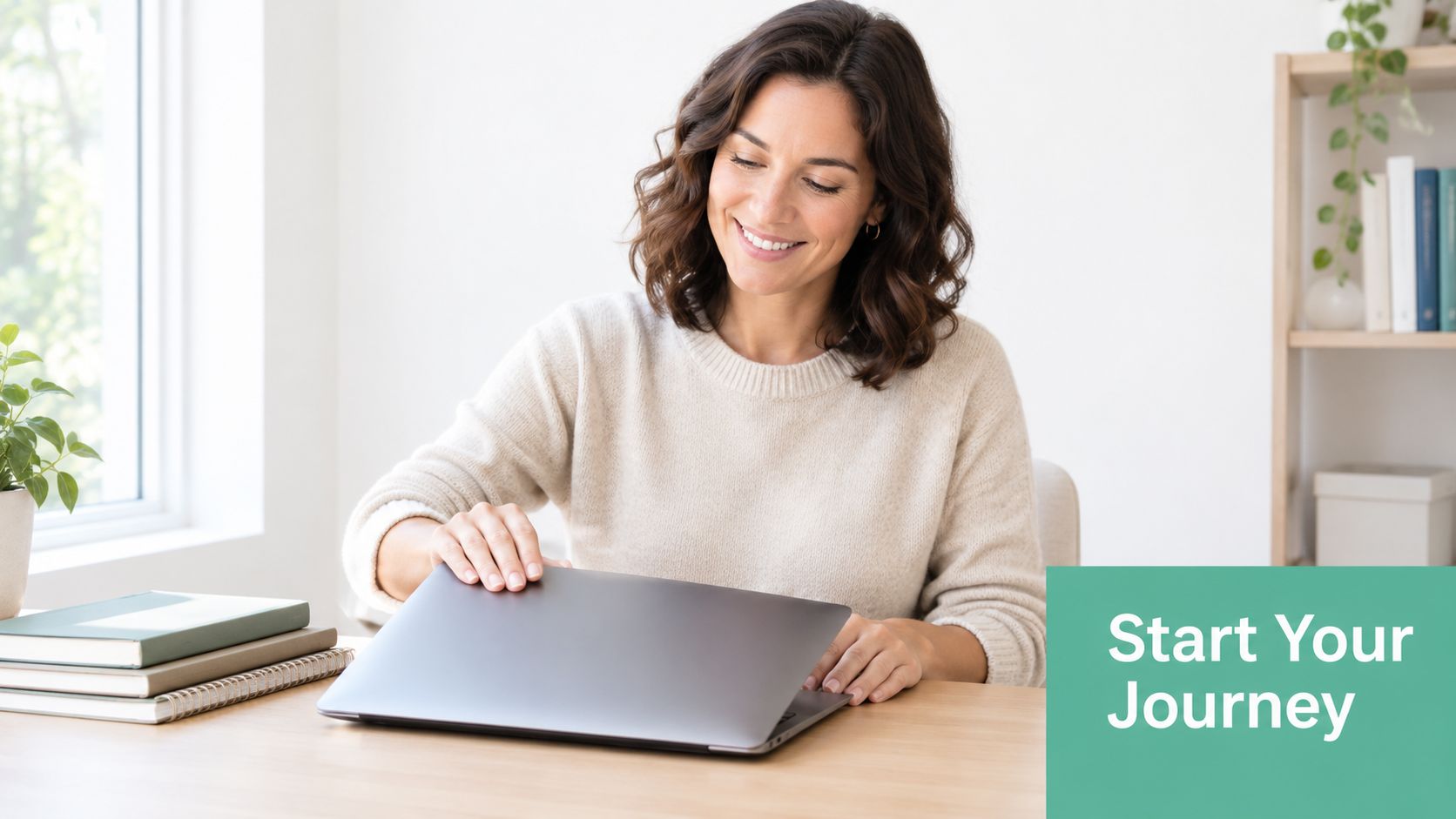 A woman smiling as she prepares to start working on her laptop at a clean, modern desk.