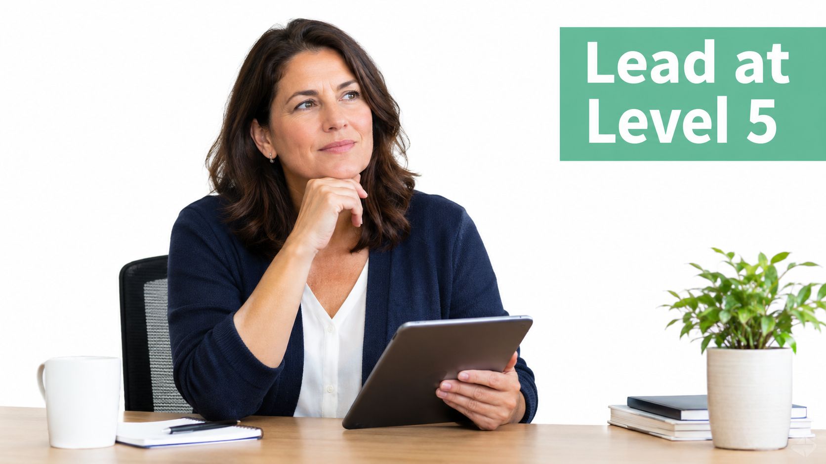 A professional woman sitting at a desk with a tablet, thinking about leadership and management level 5.