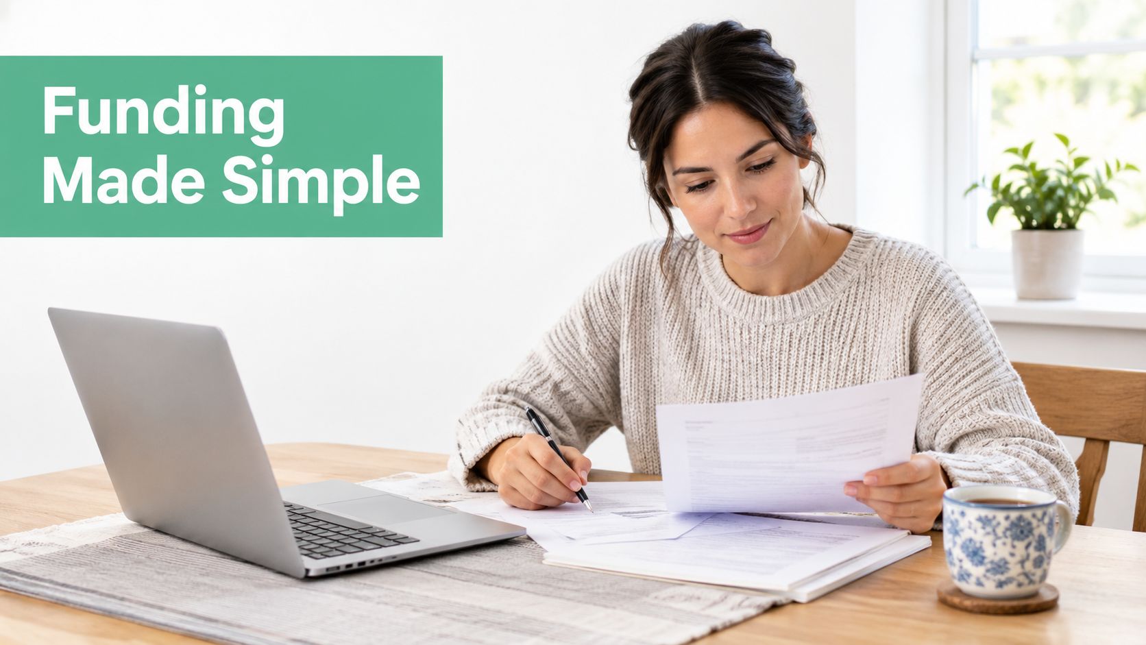 A smiling woman sitting at a desk with a laptop and documents while filling out paperwork.