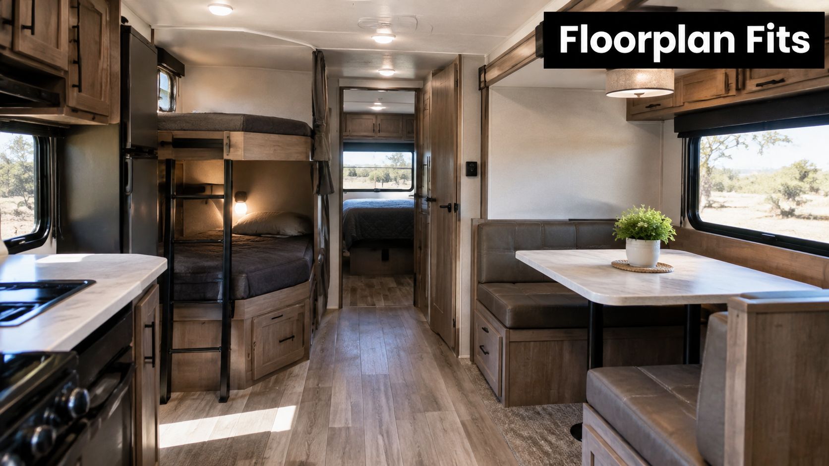 The interior view of a travel trailer showcasing bunk beds, a dinette booth, and a kitchen area.