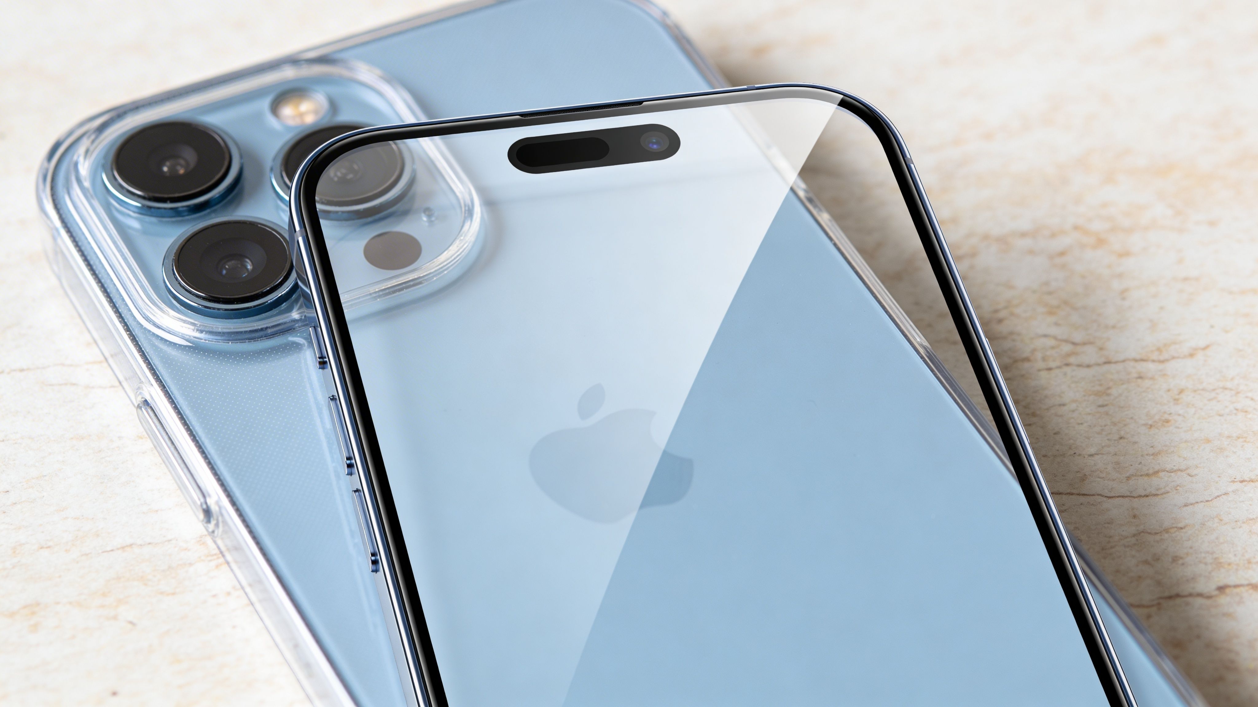 Ένα γαλάζιο iPhone 14 Pro με διαφανή θήκη σιλικόνης και προστατευτικό οθόνης τοποθετημένο πάνω σε ξύλινη επιφάνεια.