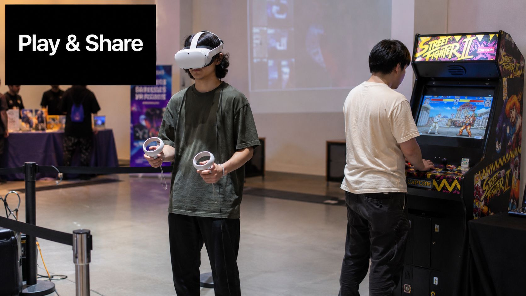 A person uses a virtual reality headset while another plays a Street Fighter II arcade machine nearby.