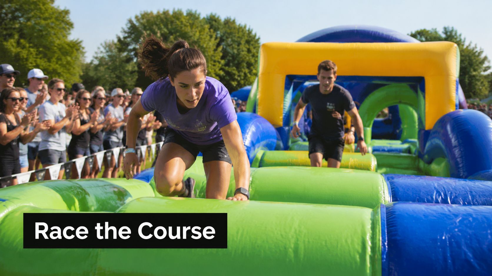 A woman and a man competing on a colorful inflatable obstacle course during a fun outdoor event.