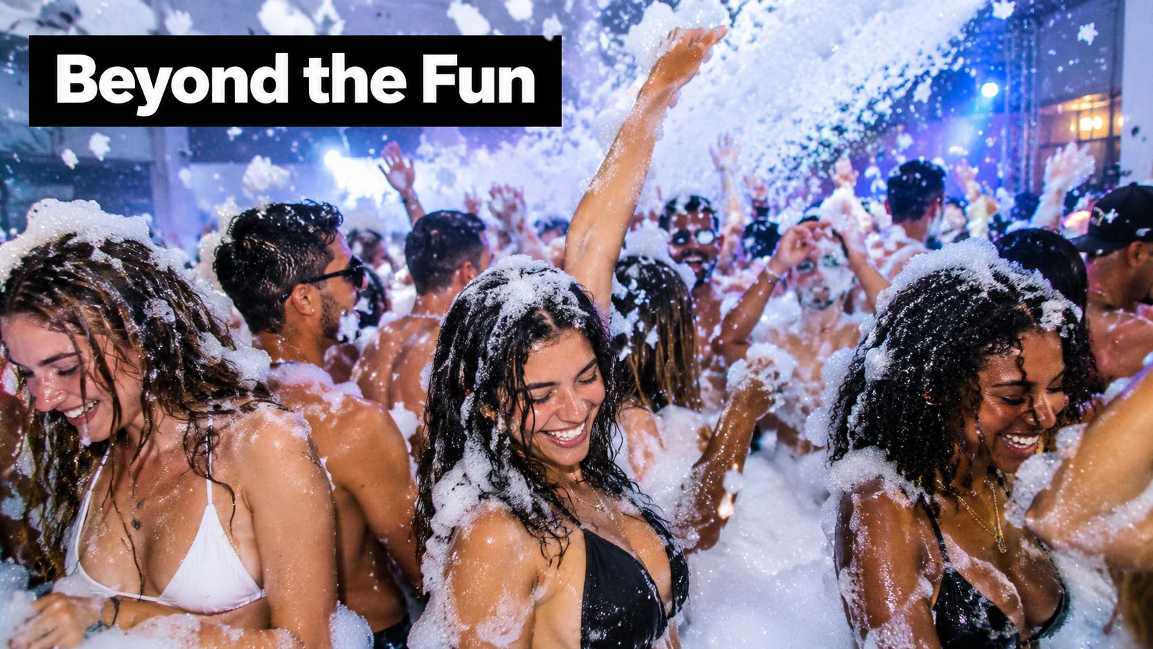 A group of happy young people dancing and having fun at an energetic outdoor foam pit party.