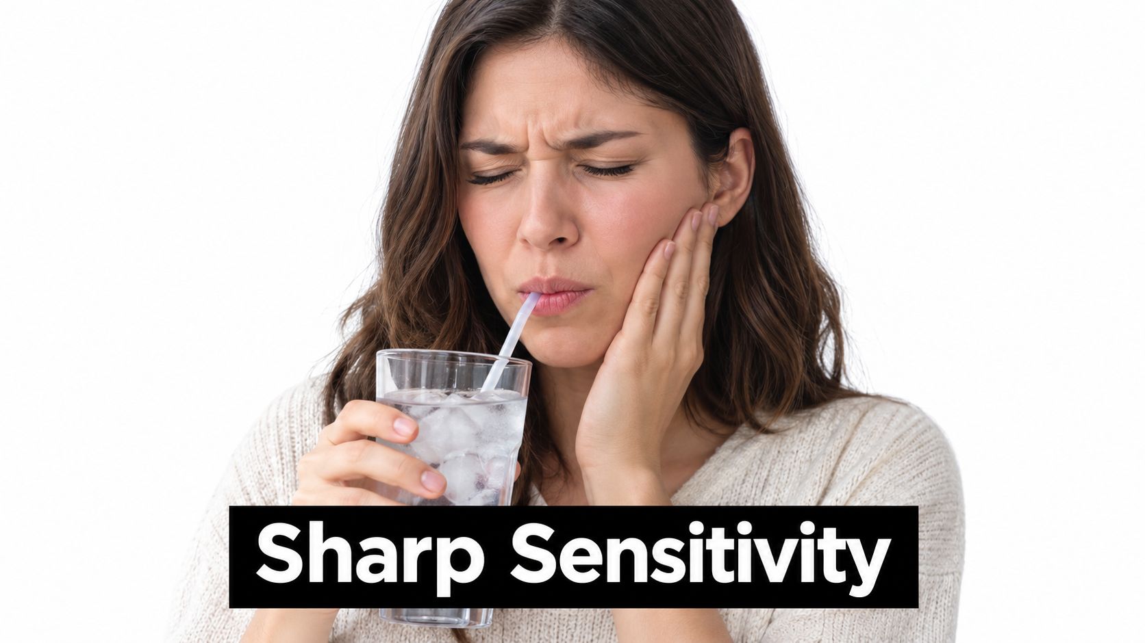 A woman grimacing in pain while drinking ice water, illustrating the discomfort of sharp tooth sensitivity.