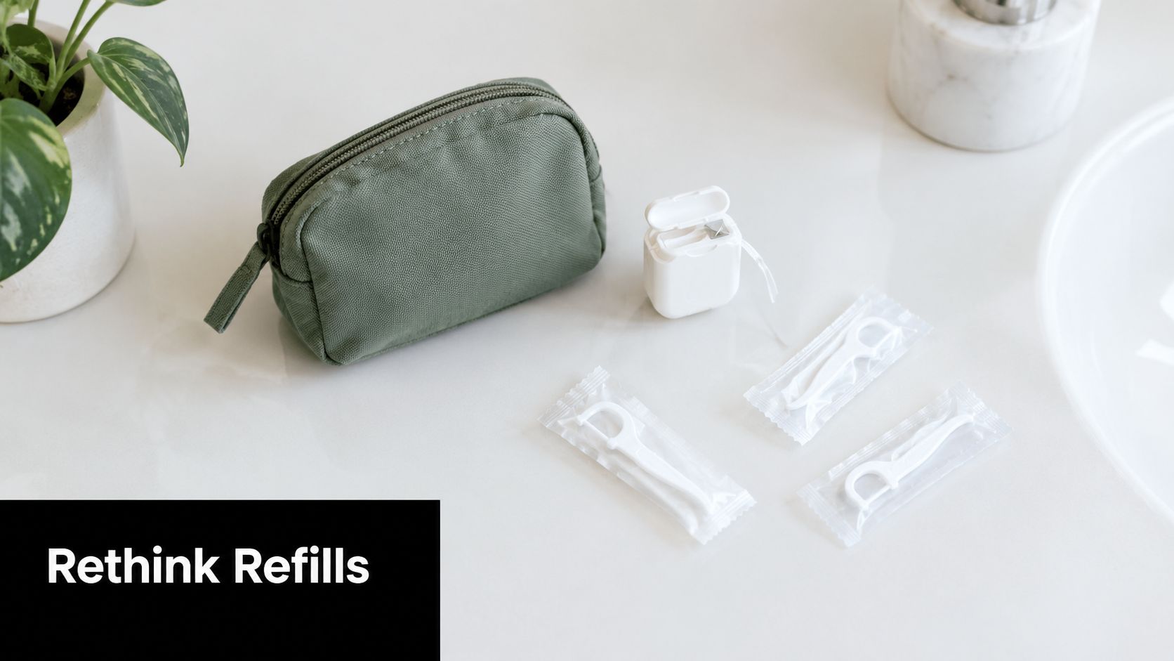 A green toiletry bag with dental floss and individually wrapped floss picks on a white countertop.