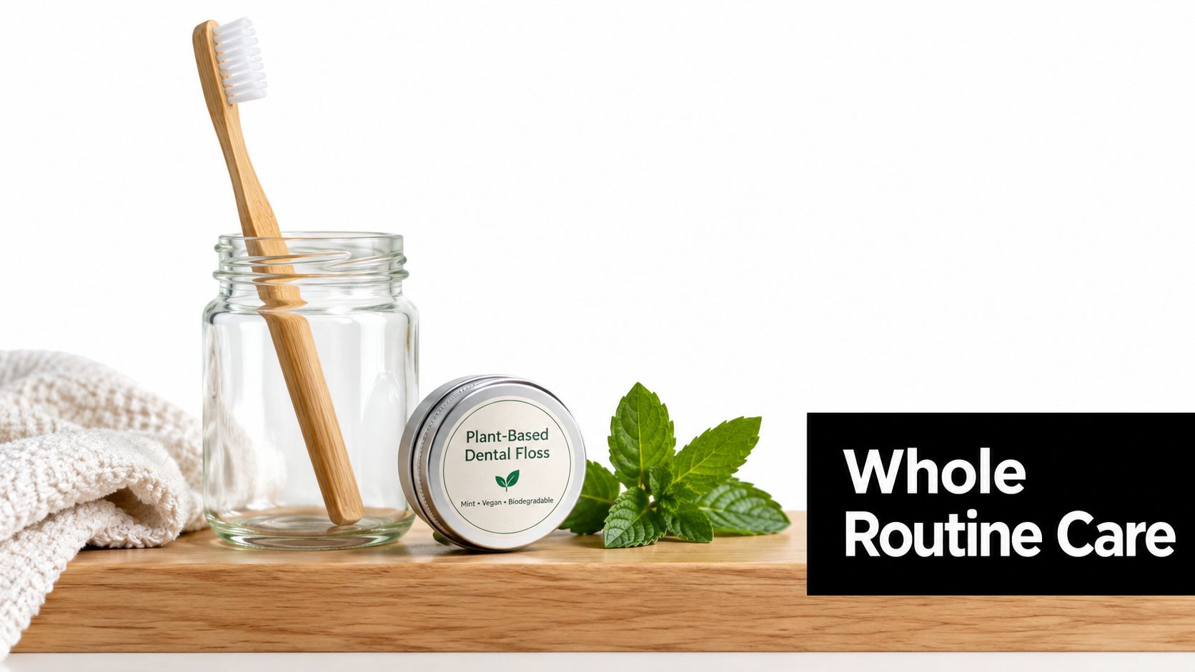 A bamboo toothbrush in a glass jar and a tin of plant-based dental floss near mint leaves.