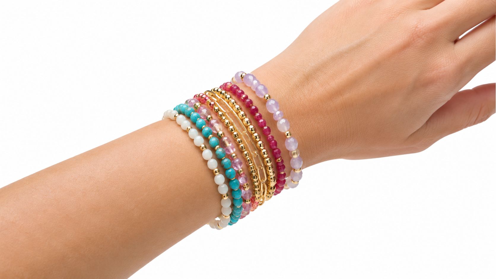 A woman's wrist adorned with a stack of colorful beaded bracelets with gold accents on a white background.
