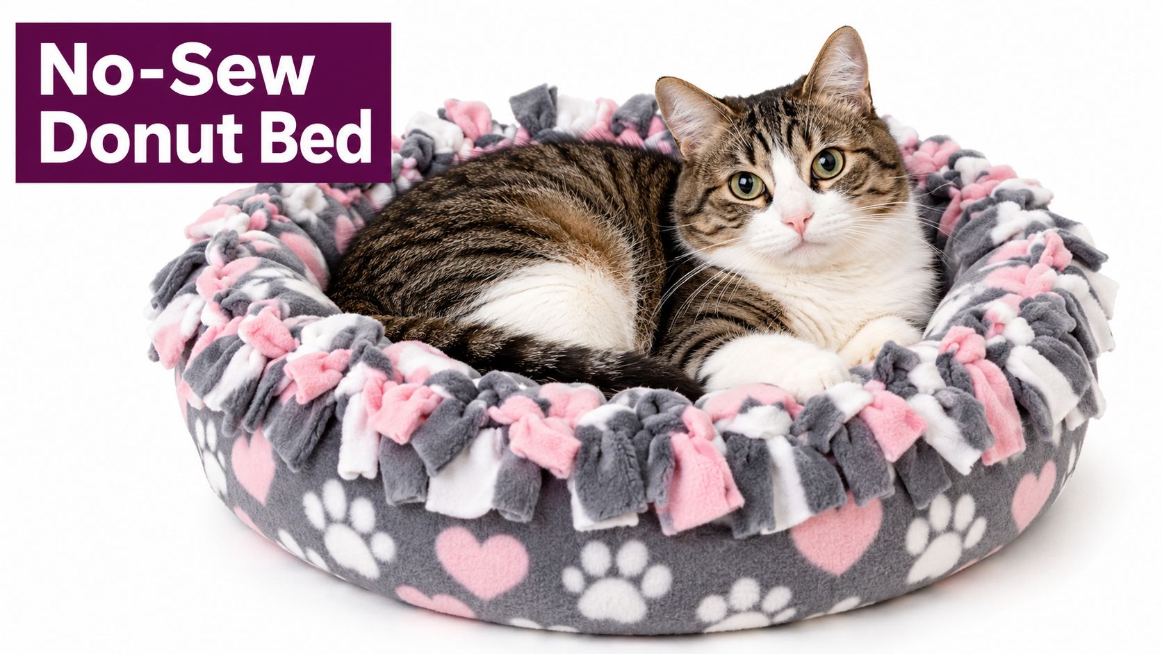 A cute tabby cat resting inside a cozy, handmade gray and pink fleece no-sew donut bed.