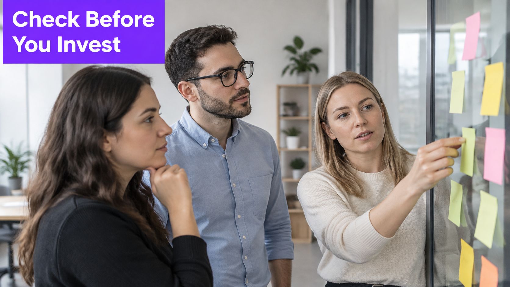 A professional team of three people collaborating and brainstorming together in a modern office environment.