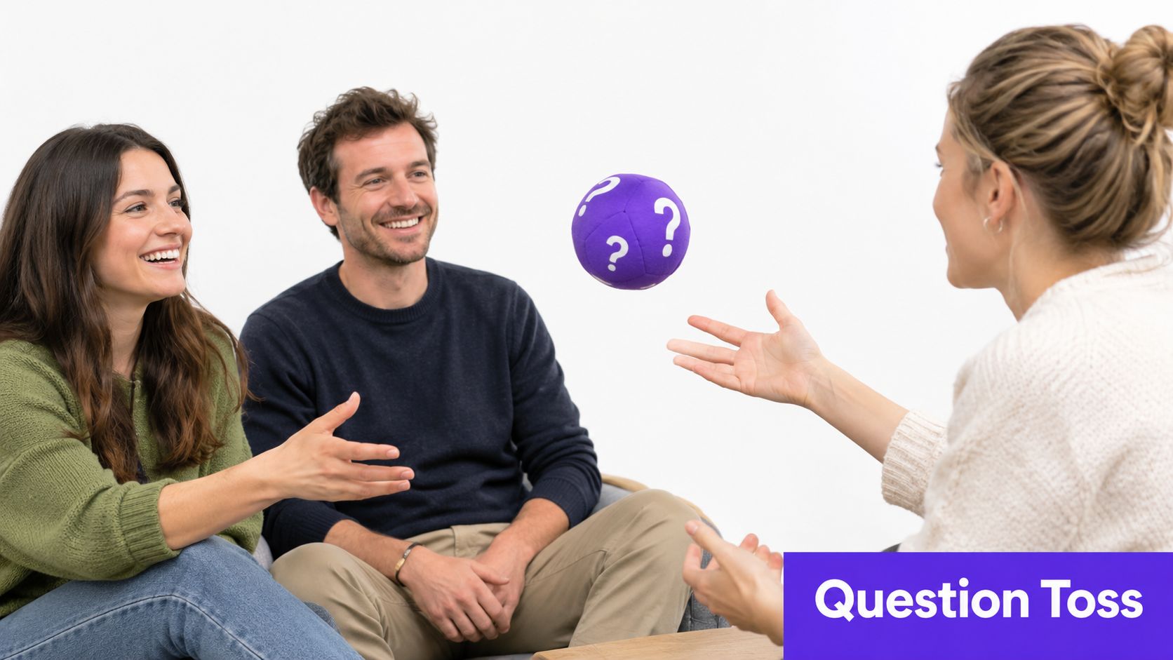 Three people smiling and playing with a purple question mark ball in an office setting.