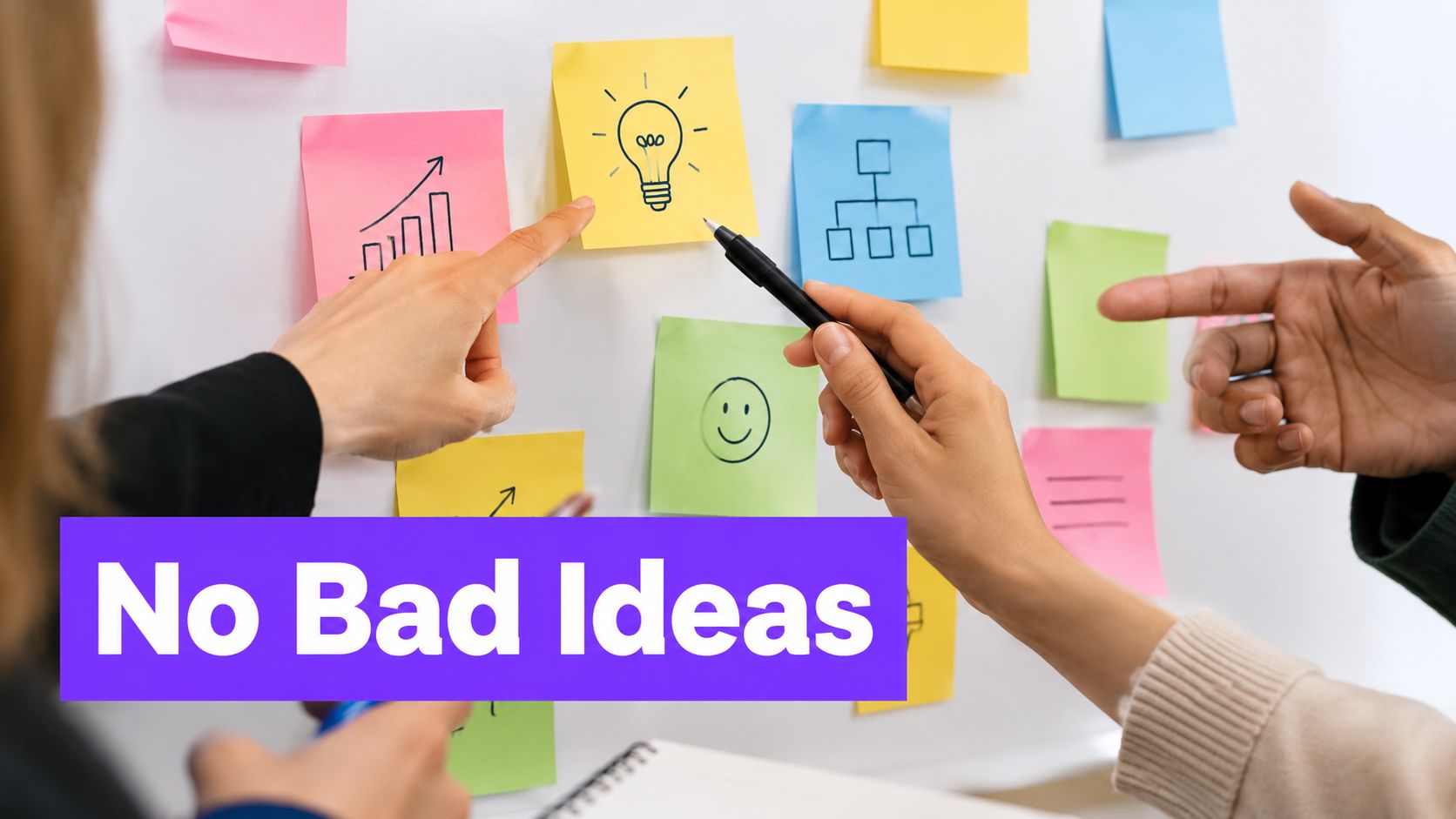 A diverse group of professionals brainstorming together and pointing at sticky notes on a whiteboard.