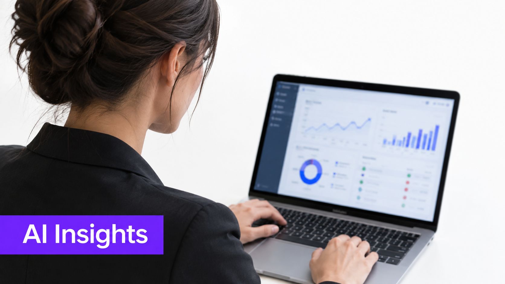 A businesswoman wearing a black blazer works on a laptop displaying data analytics and charts.