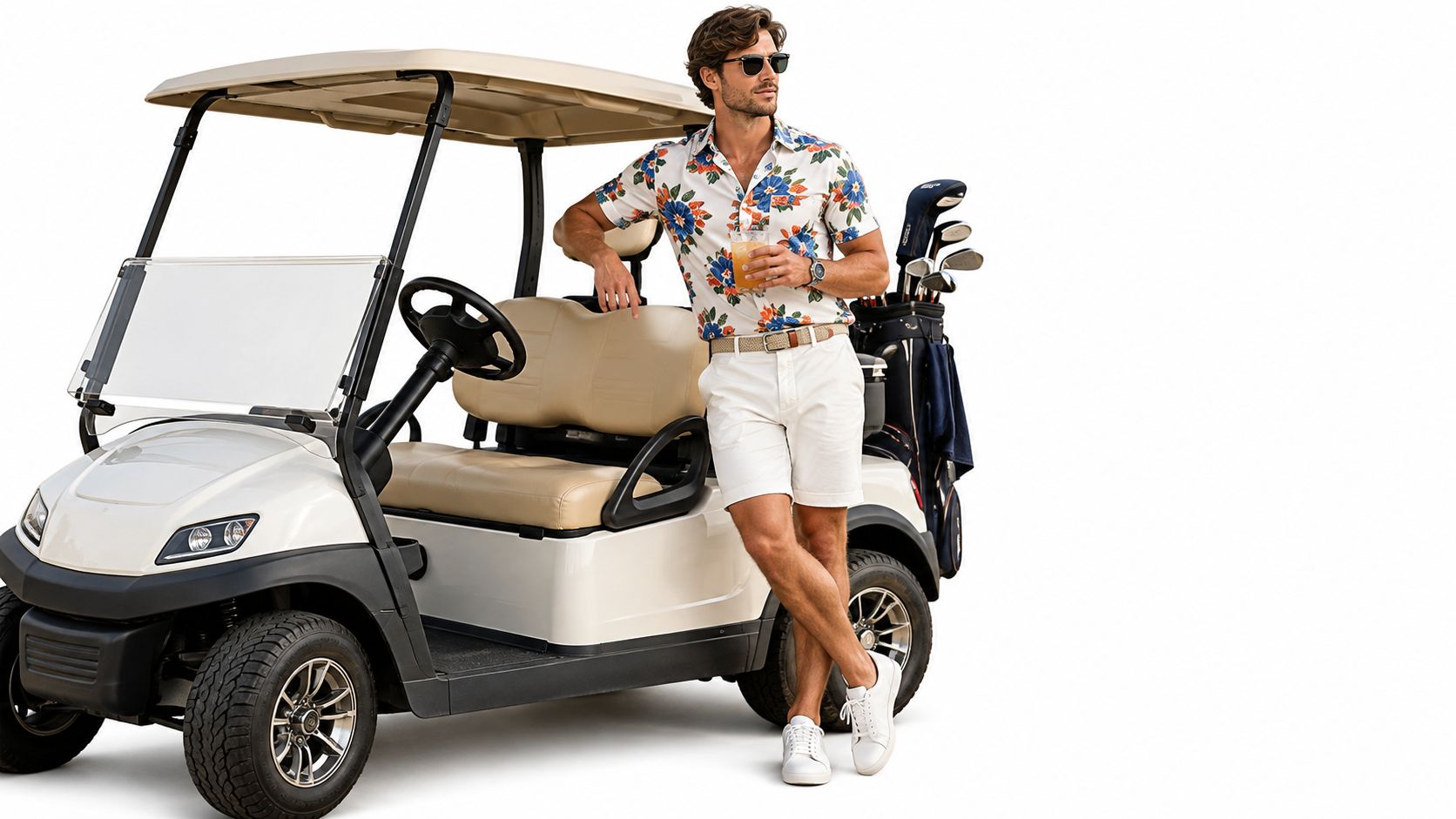 A stylish man wearing a floral shirt and white shorts standing next to a golf cart.