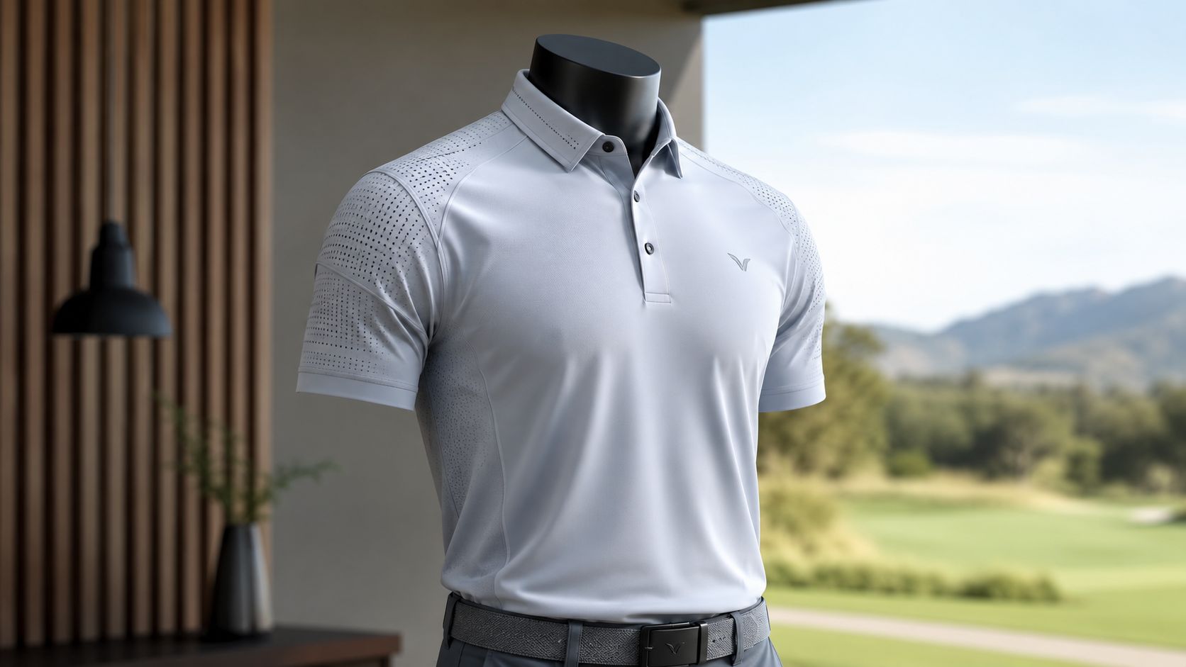 A light grey performance golf polo shirt displayed on a mannequin in a modern room setting.