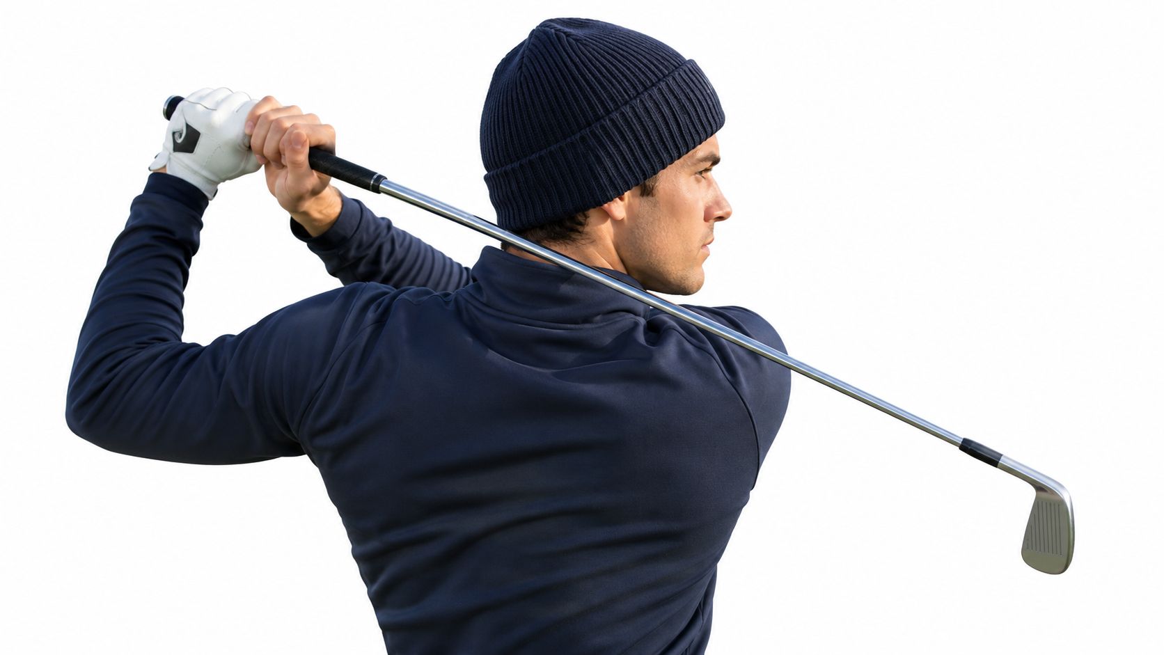 A professional golfer wearing a dark navy beanie swings a golf club against a white background.