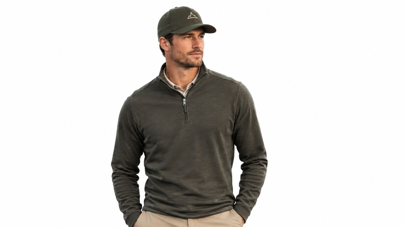 A man wearing a dark olive green quarter-zip sweater and a matching snapback hat looking away.