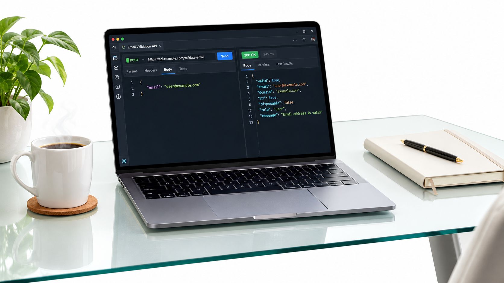 A modern laptop on a glass desk displaying an email validation API response on a dark screen.