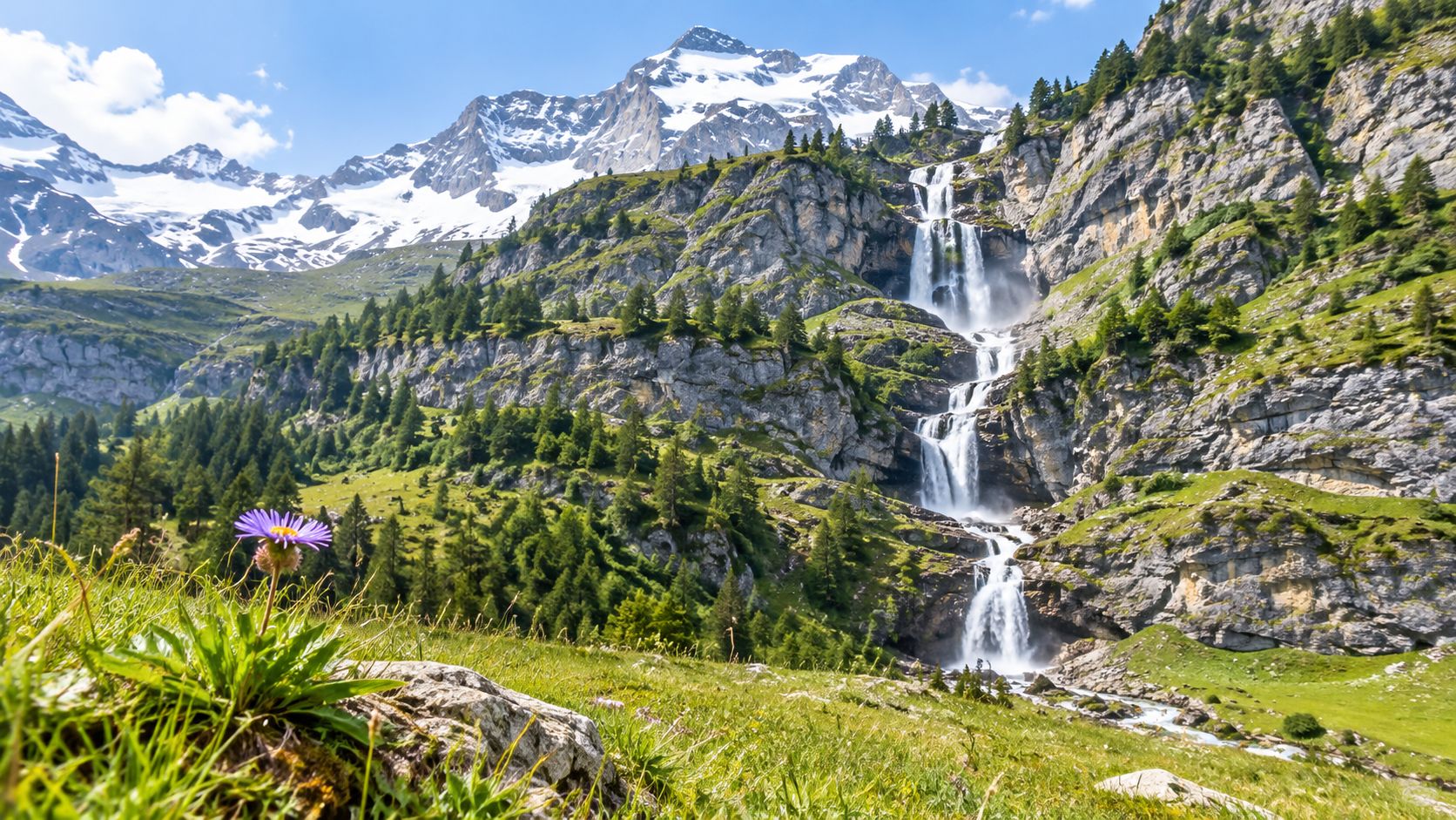 A picturesque mountain waterfall cascading down rocky cliffs surrounded by a vibrant green meadow and wildflowers.